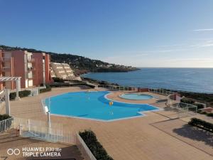 een groot zwembad met de oceaan op de achtergrond bij Escale Paradisiaque à Sète in Sète