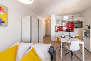 a living room with a bed and a table and a kitchen at Studio Cosy les Perruches in Thonon-les-Bains