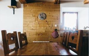 ein Esszimmer mit einem Tisch und einer Uhr an der Wand in der Unterkunft Au cœur du massif jurassien in Les Rousses