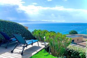 patio z krzesłami i oceanem w tle w obiekcie Ajaccio maison bord de mer dans résidence avec piscine w Ajaccio