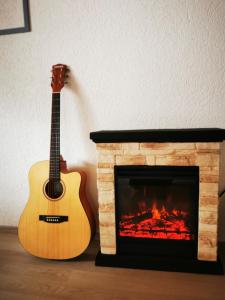 ディンゴルフィングにあるFerienwohnung Hertreiter in Dingolfing 110qmの暖炉の横にギター