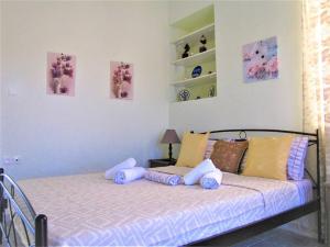 a bedroom with a bed with pillows on it at Toula's Garden - View Apartment in Moúdhros