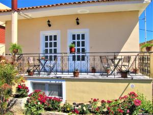 a balcony with potted plants on a house at Toula's Garden - View Apartment in Moúdhros