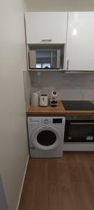 een kleine keuken met een fornuis en een magnetron bij Appart Cosy Auber Porte de Paris in Aubervilliers