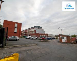 a parking lot with cars parked in front of a building at Contractor Stays by Furnished Accommodation Liverpool - Free Parking in Liverpool