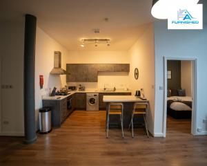 Contractor Stays by Furnished Accommodation Liverpool - Free Parking في ليفربول: مطبخ مع طاولة وكراسي في غرفة