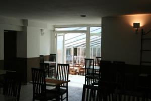 a dining room with chairs and tables and a window at Hotel Le Bois Des Espeisses in Nîmes