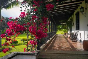 a porch of a house with pink flowers on it at Hotel Hacienda Supracafe in Popayan