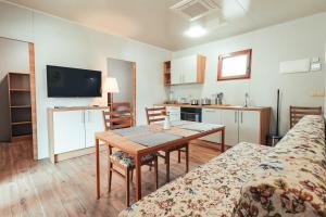 a living room with a table and a kitchen at Terme Banovci - Mobilne hiške Med Brajdami in Banovci