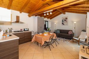 eine Küche und ein Wohnzimmer mit einem Tisch, einer Küche und einem Sofa in der Unterkunft Belvedere 3 in Piedimonte Etneo