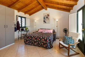 ein Schlafzimmer mit einem Bett und einem Stuhl in der Unterkunft Belvedere 3 in Piedimonte Etneo