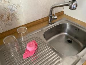 Um lavatório com dois copos e uma rosa. em La Azohia em La Azohia