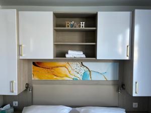 een kast met een schilderij erop in een slaapkamer bij Floating Sea House MAREA in Portorož