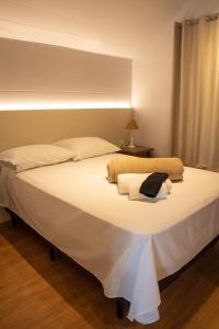 1 cama blanca grande en una habitación con ventana en Cabana Serra Grande Sossego, en Gramado
