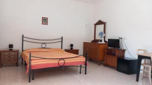 een slaapkamer met een bed, een dressoir en een spiegel bij B&B Il Cortile del Sole in Olmedo