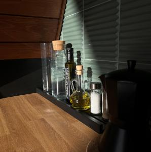 un estante con botellas y vasos sobre una mesa en Mirador Cottage en Slavske