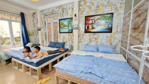 2 bambini che dormono sui letti in una camera da letto di H2 homestay phố cổ check in tự động a Hanoi