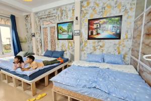 two children laying on beds in a bedroom at H2 homestay phố cổ check in tự động in Hanoi