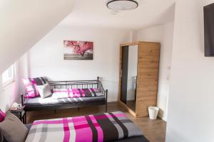 ein kleines Zimmer mit einem Bett und einem Spiegel in der Unterkunft Villa Preisendanz in Ringsheim