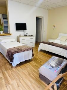um quarto de hotel com duas camas e uma televisão em Casa Maka' em Olbia
