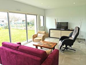 sala de estar con sofá, mesa y sillas en La Belle Evasion - 5 personnes, en Saint-Vincent-sur-Jard
