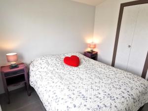 uma almofada de coração vermelho numa cama num quarto em La Belle Evasion - 5 personnes em Saint-Vincent-sur-Jard