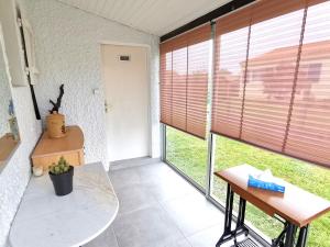 um quarto com uma mesa e uma janela com persianas em La Belle Evasion - 5 personnes em Saint-Vincent-sur-Jard