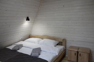 łóżko z białą pościelą i poduszkami w pokoju w obiekcie Soul House w mieście Pilipets