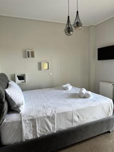 a bedroom with a white bed with two towels on it at EVa's Luxury Apartments No 4 in Artemida