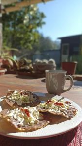 zwei Scheiben Pizza auf einem Teller auf einem Tisch in der Unterkunft Hostal Casa 4 Estaciones, CoLiving & Nature in San Cristóbal de las Casas