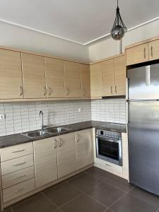 a kitchen with wooden cabinets and a stainless steel refrigerator at EVa's Luxury Apartments No 4 in Artemida
