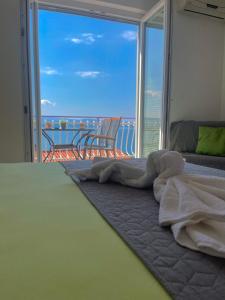a bedroom with a bed and a view of the ocean at Apartmani ABA in Stanići