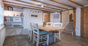 - une salle à manger avec une table et des chaises en bois dans l'établissement Church Cottage - Quaint farmhouse cottage with modern twist, Dog Friendly, Sleeps 6-7, à West Down