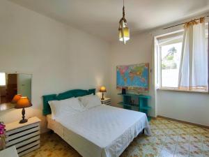 1 dormitorio con cama blanca y ventana en La Caura di Casa Camilla Journey en Marina Serra