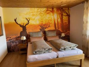 a bedroom with a bed with a painting on the wall at Pension Altvogtshof in Eisenbach