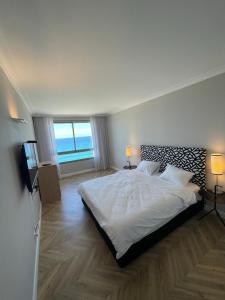 - une chambre avec un lit, deux lampes et une télévision dans l'établissement Apartment on Haifa, à Haïfa