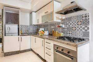 a kitchen with white cabinets and a stove at Lovely city center flat near the old Medina in Casablanca