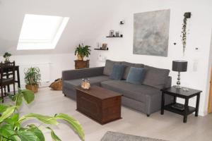uma sala de estar com um sofá cinzento e uma mesa em Ferienwohnung Wintereck em Bühlertal