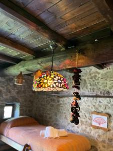 Habitación con cama y lámpara de araña de cristal de colores. en Casa Balsamo, en Borzonasca