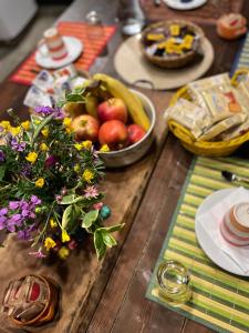 drewniany stół z miską owoców i wazonem kwiatów w obiekcie Casa Balsamo w mieście Borzonasca