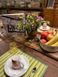 una mesa con una taza de café y un bol de fruta en Casa Balsamo, en Borzonasca