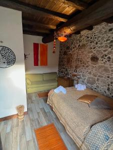a bedroom with a bed and a stone wall at Casa Balsamo in Borzonasca