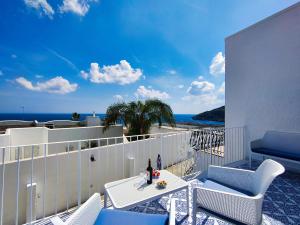 balcón con mesa, sillas y vistas al océano en La Caura di Casa Camilla Journey en Marina Serra