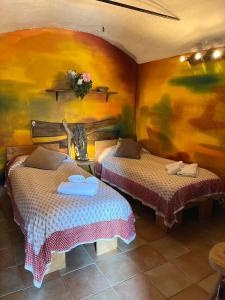 two beds in a room with a painting on the wall at Casa Balsamo in Borzonasca