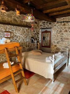 1 dormitorio con cama y pared de piedra en Casa Balsamo, en Borzonasca