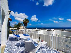 Un balcón con sillas blancas y vistas al océano. en La Caura di Casa Camilla Journey en Marina Serra
