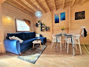 a living room with a blue couch and a table at Domki U Ali w Rewalu in Rewal +21 photos