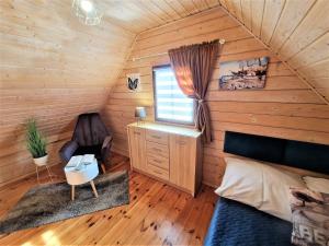 a bedroom with a bed and a desk and a chair at Domki U Ali w Rewalu in Rewal