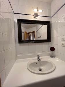 a white bathroom with a sink and a mirror at Chalet with mountainview in Oz