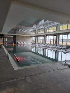 an empty swimming pool with chairs in a building at Alexis apartament Dziwnów in Dziwnów